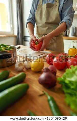 Close up of hands of man preparing pepper to use in cooking healthy meal, soup in the kitchen. Italian cuisine concept. Selective focus. Vertical shot