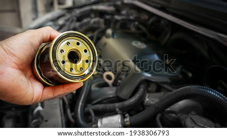 Close up hands of mechanic doing car service and maintenance. Oil and fuel filter changing.Car maintenance concept.