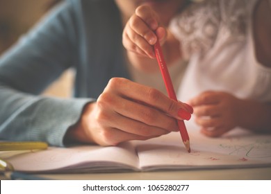 Close up of hands mother an little girl writing together. Focus is on hands. - Powered by Shutterstock