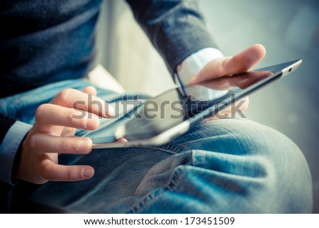 close up hands multitasking man using tablet, laptop and cellphone connecting wifi
