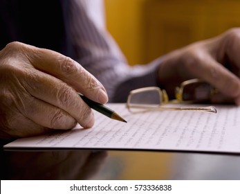 Close Up Of A Hands Of An Old Man, Writing In A Paper.
