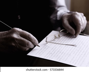 Close Up Of A Hands Of An Old Man, Writing In A Paper.