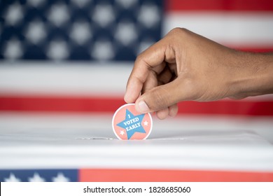 Close Up Of Hands Placing I Voted Early Sticker Inside The Ballot Box - Concept Of Early Voting In Us Election.