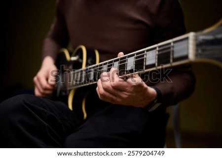 Close Up of Hands Playing a Guitar in a Warm and Cozy Setting Filled with Music and Art