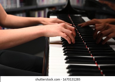 Nahaufnahme von Händen, die Klavier auf einem schönen Flügel spielen.