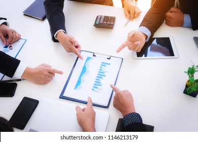 Close up of hands pointing document graph chart of company's marketing share in meeting room. - Shutterstock ID 1146213179