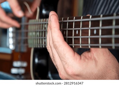 Close up of hands practicing fingerstyle technique on an electric bass guitar. Perfect for concepts related to music lessons, education, skill development, and continuous practice.