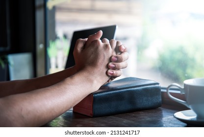 Close Up Hands Praying On The Bible And On The Wooden Desk With Computer Laptop, Online Live Church For Sunday Service, Home Churc