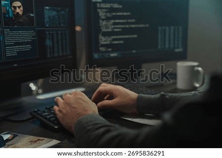Close up of the hands of a programmer in a gray sweater, writing program code