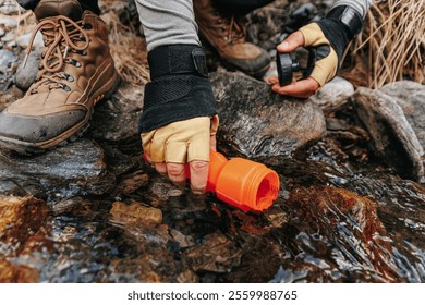 close up of a hands Riverbank Rejuvenation Latino Traveler Man Takes a Break, Filling His Bottle from a Wooded Water Source During the Trek. - Powered by Shutterstock