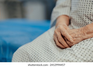 Close up of hands of senior patient on examination table in the hospital. Concept of fear and anxiety about health problems in elderly people. - Powered by Shutterstock