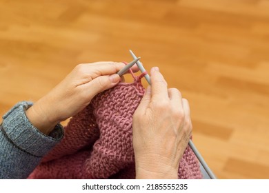 Close Up Hands Of An Senior Woman. Knitting Blanket From Yarn.