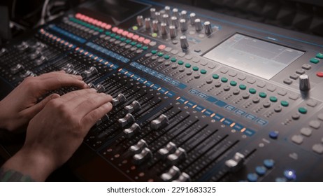 Close up hands shot of sound engineer using mixing console, remote control for adjusting sound, audio mixer. Musician changes the volume level, creates music. Sound recording studio. Music production. - Powered by Shutterstock