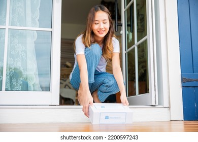 Close Up Hands Of Sick Asian Woman Sitting At Door To Receive Medication First Aid Pharmacy Box Package From Hospital Delivery Service At Floor Home, Drugstore Internet Online Medical Business