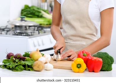 Close Up Of Hands Slicing And Chopping Raw Vegetables As Meal Preparation In A Kitchen 