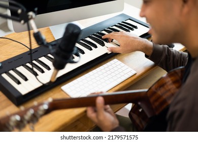 Close up hands songwriter playing piano keyboard and guitar in home studio. Professional musician audio equipment at Recording studio.