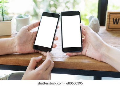 Close Up Hand's Two Young Asian Girls Using Smart Phone In The Coffee Shop With Blank White Screen For For Your Advertising Picture Or Text Message.