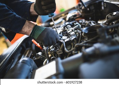 Close up hands of unrecognizable mechanic doing car service and maintenance. - Shutterstock ID 601927238