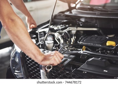 Close up hands of unrecognizable mechanic doing car service and maintenance. - Shutterstock ID 744678172