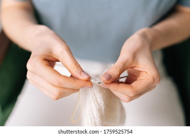 Close up of hands of unrecognizable woman knitting handmade clothes with spokes using white wool yarn. Concept of leisure activity. - Shutterstock ID 1759525754