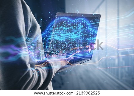 Close up of hands using laptop with abstract glowing cloud hologram screen on blurry background. Database, science and communication concept. Double exposure