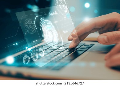 Close Up Of Hands Using Laptop Keyboard With Abstract Glowing Fingerprint Interface On Blurry Background. Login And Authorization Concept. Double Exposure