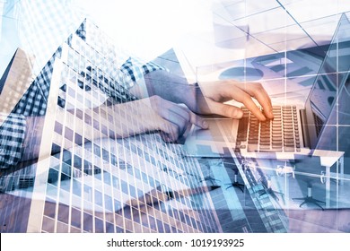 Close up of hands using laptop placed on desk with abstract city view. Technology, finance and innovation concept. Double exposure  - Shutterstock ID 1019193925