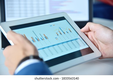 Close up of hands using tablet device with business report. Business and financial success concept.