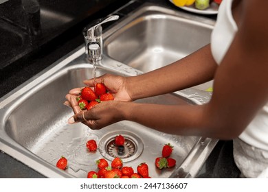 close up of hands Washing Fresh Red Strawberries Under Running Tap Water in Stainless Steel Sink - Powered by Shutterstock