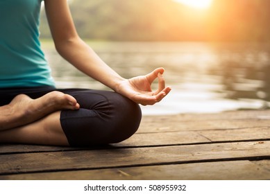Close up hands. Woman do yoga relax outdoor. Woman exercising pose vital and meditation for fitness lifestyle club at the outdoors nature background. Healthy and Yoga Concept

