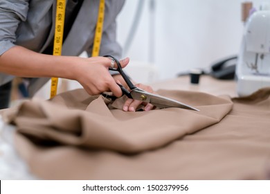 Close up Hands woman fashion designer tailor cutting fabric working and sewing, creative design in studio tailor shop, occupation owner small business concept