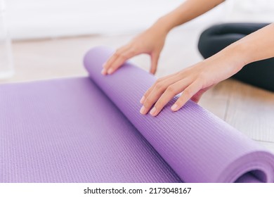 Close Up Hands Of Woman Rolling Yoga Mat, Preparing For Doing Yoga. Working Out At Home Or In Yoga Studio. Healthy Habits, Keep Fit, Weight Loss Concepts.