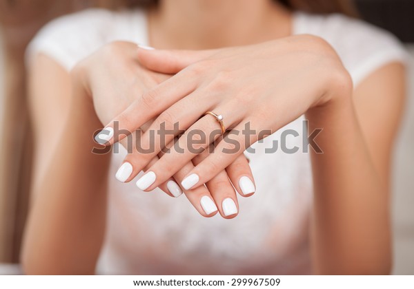 Close up of hands of woman showing the ring with\
diamond. She is engaged