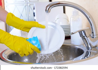 Close up hands of woman washing dishes in kitchen - Shutterstock ID 172382594