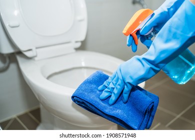 close up hands women wearing protect glove blue using liquid cleaning solution cleaning flush toilet, disinfection and hygiene concept - Shutterstock ID 1908571948