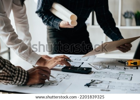 Close up of hands working brainstorming and measuring for cost estimating on paperworks and floor plan drawings about design architectural and engineering for houses and buildings.
