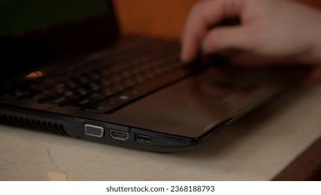 Close up of hands working at the laptop of the computer. Stock footage. Typing on keyboard with a glass of water standing near.