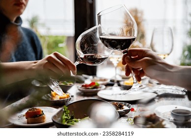 Close up of hands young couple man and woman clinking with glasses of red wine at restaurant - Powered by Shutterstock