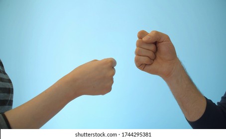 Close Up Hands Of Young Couple Playing Rock Paper Scissors On Blue Background Indoors.