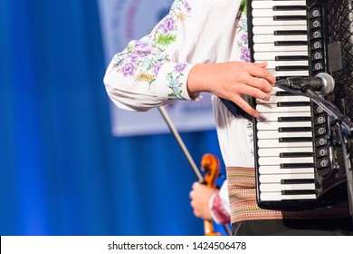 Close Up Of Hands Of Young Romanian Man Perform A Folk Music On Accordion In Traditional Folkloric Costume. Folklore Of Romania