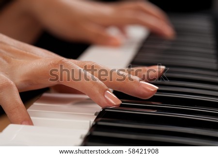 Close up of the hands of a young woman playing piano