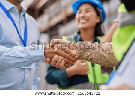 Close up of a handshake between construction worker and foreman sealing a deal on site. Businessman and architect shaking hands as a symbol of partnership at construction site. Agreement reached.