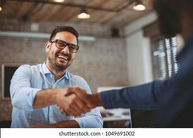 Close up of handshake in the office - Shutterstock ID 1049691002