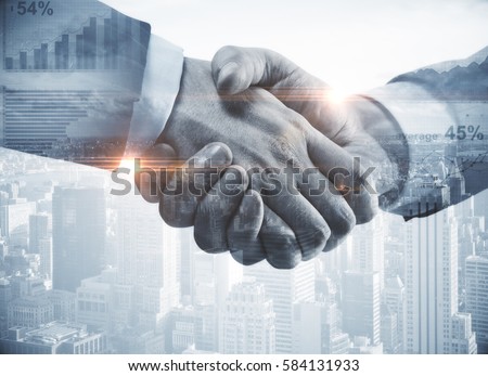 Close up of handshake on abstract city background.Teamwork concept. Double exposure. Filtered image