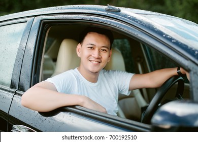 Close Up Of A Handsome Asia Man Siting In His Car.Travel Concept..