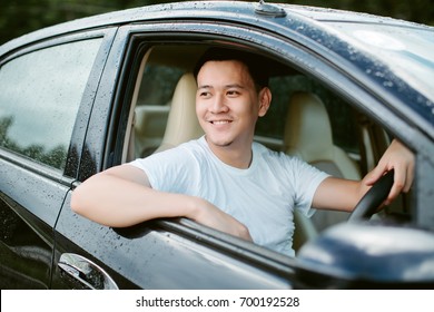 Close Up Of A Handsome Asia Man Siting In His Car.Travel Concept..