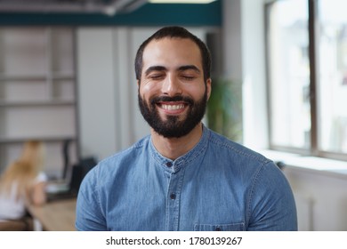 Close up of a handsome cheerful male entrepreneur smiling with his eyes closed - Shutterstock ID 1780139267