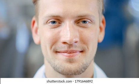 Close Up Of A Handsome Young Blond Male Portrait Shot. He's A Professional Employee. Man Looks And Smiles At Camera. Expresses Success And Happiness. He Has Blue Eyes And Light Beard.