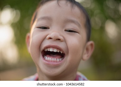 Close up of Happy asian boy smiling in the park. Little Asian child portrait photo in the park.