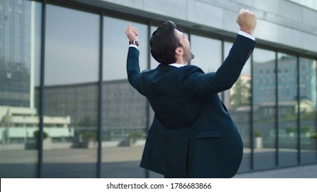 Close Up Happy Businessman Celebrating Victory Near Modern Building. Young Business Man Getting Promotion Outdoors. Cheerful Man Enjoying Achievement At Urban Street.